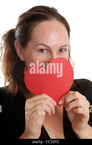 Frau hält rotes Papierherz über Gesicht unter den Augen Stockfoto