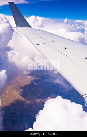 Wolken, Flügel des Düsenflugzeug & Erde. Stockfoto