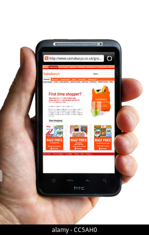 Einkaufen online bei Sainsburys auf einem HTC-smartphone Stockfoto