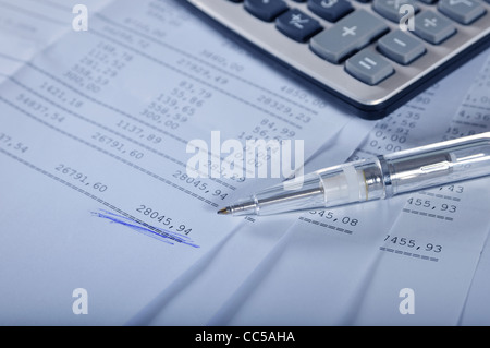 Drucke des Finanzberichts auf Bögen mit Stift und Taschenrechner Stockfoto