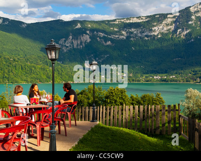 Touristen im Café neben Lac Aiguebelette Avant zahlt Savoyard und Umgebung den französischen Alpen in Süd-Ost-Frankreich Stockfoto