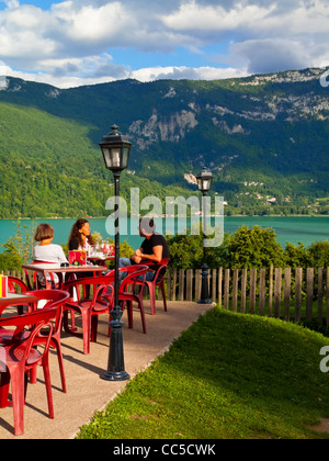 Touristen im Café neben Lac Aiguebelette Avant zahlt Savoyard und Umgebung den französischen Alpen in Süd-Ost-Frankreich Stockfoto