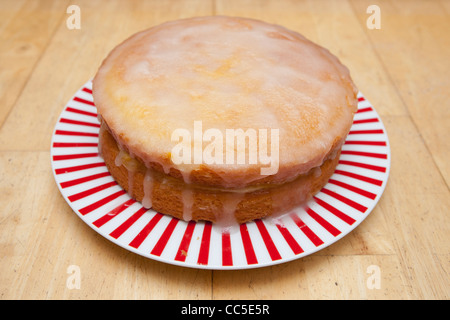 Ein frisch gebackener Zitronenkuchen Nieselregen auf einem Holztisch Stockfoto