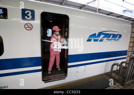 Reiniger in ihren rosa Uniformen bereiten eine Reihe N700 Shinkansen-Hochgeschwindigkeitszug im Bahnhof Tokio, Japan. Stockfoto