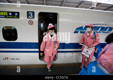 Reiniger in ihren rosa Uniformen bereiten eine Reihe N700 Shinkansen-Hochgeschwindigkeitszug im Bahnhof Tokio, Japan. Stockfoto