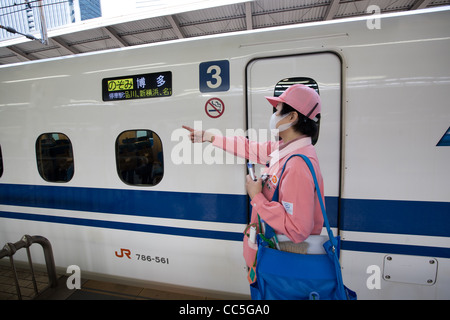 Reiniger in ihren rosa Uniformen bereiten eine Reihe N700 Shinkansen-Hochgeschwindigkeitszug im Bahnhof Tokio, Japan. Stockfoto