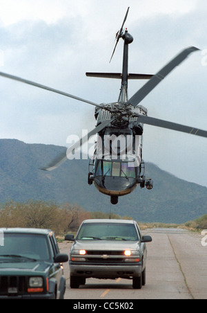 U.S. Customs and Border Patrol Blackhawk Hubschrauber schüchtert zwei Fahrzeuge auf einem entfernten Landebahn in Amerikas Südwesten Grenzregion. Stockfoto