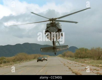 U.S. Customs and Border Patrol Blackhawk Hubschrauber schüchtert zwei Fahrzeuge auf einem entfernten Landebahn in Amerikas Südwesten Grenzregion. Stockfoto