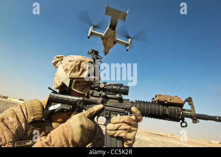 Ein US-Marine bietet Sicherheit wie ein MV-22 Osprey-Transport, das Flugzeug an der iranischen Grenze 30. Dezember 2011 in Zaranj Nimroz Provinz, Afghanistan landet Stockfoto