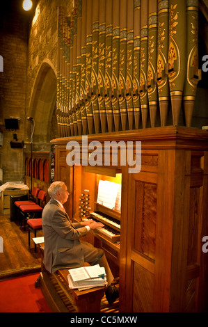 Älterer kaukasischer Mann, der in einer britischen Kirche die Orgel spielt. Stockfoto