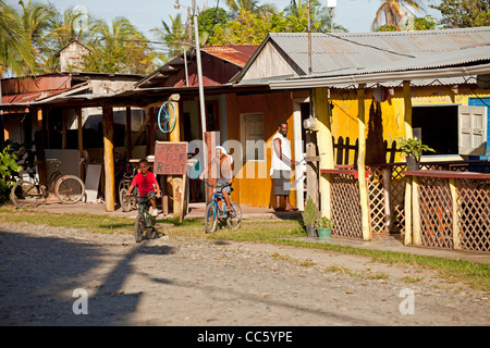 Kinder mit dem Fahrrad in das kleine Dorf von Cahuita, Karibikküste, Costa Rica, Mittelamerika Stockfoto