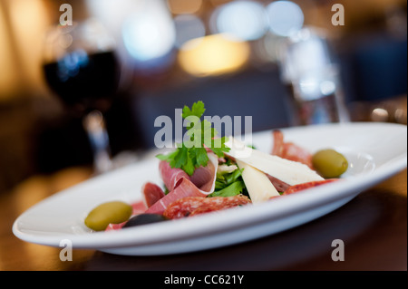 Italienischer Schinken, Käse und Oliven mit einem Glas Rotwein Stockfoto
