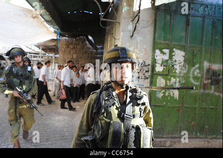 Israelische Soldaten auf Patrouille in der Altstadt von Hebron, eine Gruppe von jüdischen Siedlern zu eskortieren. Stockfoto