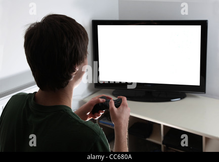 Junge männliche leere sitzen vor großen tv mit einem game-Controller in der Hand, Bildschirm bereit für Ihre eigene Grafik eingefügt werden Stockfoto