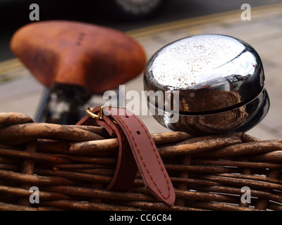 glänzende Glocke auf Vintage Fahrrad mit geflochtenen Korb und Leder Sattel Stockfoto