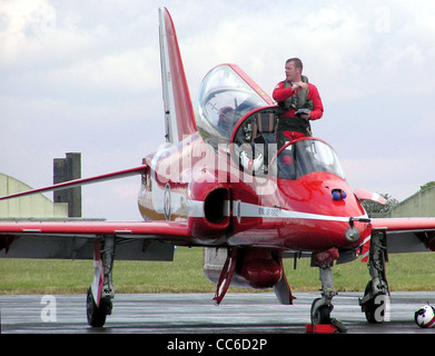 Ein Red Arrows Pilot verlässt sein Hawk-Flugzeug nach einer Demonstration. Die Red Arrows sind das Kunstflugteam der Royal Air Force, bekannt für ihr präzises Fliegen und beeindruckende Luftausstellungen auf Flugshows. Stockfoto