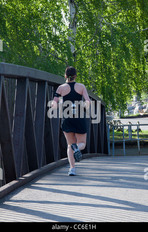 Schöne junge Frau Übung allein auf einer Brücke im Park Joggen. Stockfoto