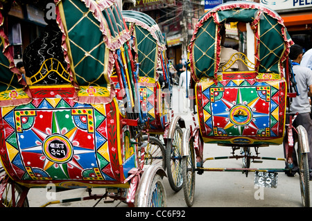 Bunte Fahrradrikschas, die durch die Straßen von Kathmandu. Stockfoto