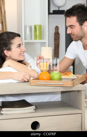 Paar genießt romantisches Essen im Schlafzimmer Stockfoto