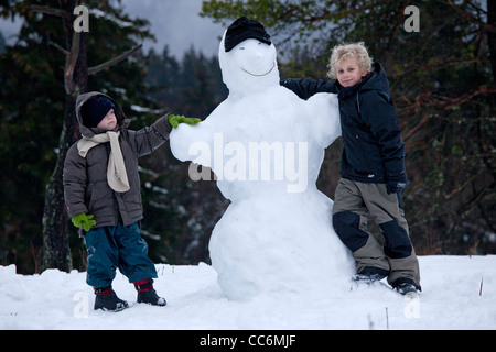 junge Burschen mit einem Schneemann am Kahler Asten in Winterberg, Sauerland, Nordrhein-Westfalen, Deutschland Stockfoto