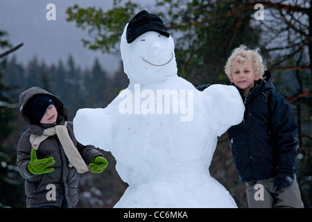 junge Burschen mit einem Schneemann am Kahler Asten in Winterberg, Sauerland, Nordrhein-Westfalen, Deutschland Stockfoto