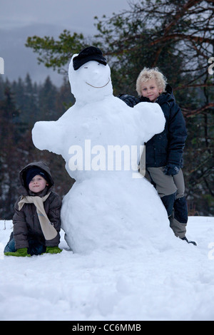 junge Burschen mit einem Schneemann am Kahler Asten in Winterberg, Sauerland, Nordrhein-Westfalen, Deutschland Stockfoto