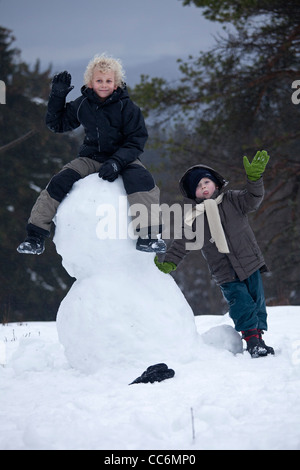 junge Burschen mit einem Schneemann am Kahler Asten in Winterberg, Sauerland, Nordrhein-Westfalen, Deutschland Stockfoto