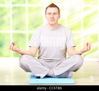 Porträt des Menschen, die Yoga Übung auf der Matte im Hause, isoliert auf weiß Stockfoto