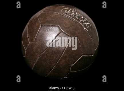 Braune Leder-Fußball auf schwarzem Hintergrund Stockfoto
