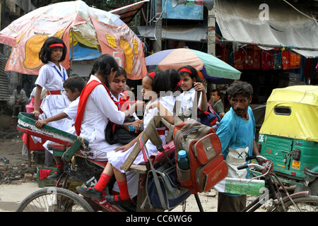 Indische Schülerinnen und Schüler auf dem Weg zur Schule in einem Pedal Rikscha. Delhi. Indien Stockfoto