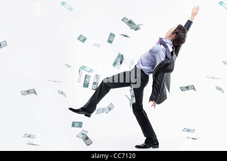 Ein Mann schwer zu stehen und zu fliegenden Geld Stockfoto