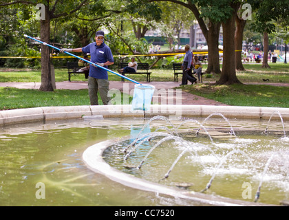 Hausmeister entfernen Schmutz vom Park Brunnen Stockfoto