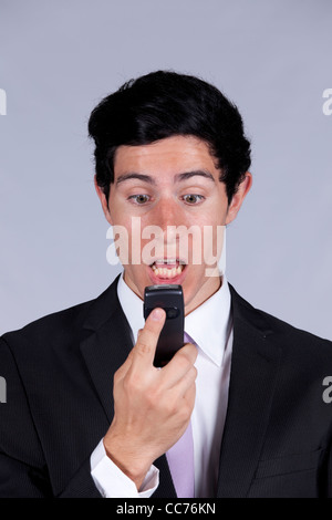 Wütend Geschäftsmann reden auf seinem Handy (isoliert auf grau) Stockfoto
