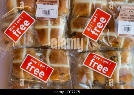 Hot Cross Buns heruntergesetzte in Lebensmittelgeschäft. Buy One Get One Free Kunststoff Verpackungen auf Lebensmittel aus Sainsburys Supermarkt Brot begegnen. Stockfoto