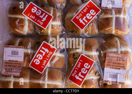 Hot Cross Buns heruntergesetzte in Lebensmittelgeschäft. Buy One Get One Free Kunststoff Verpackungen auf Lebensmittel aus Sainsburys Supermarkt Brot begegnen. Stockfoto