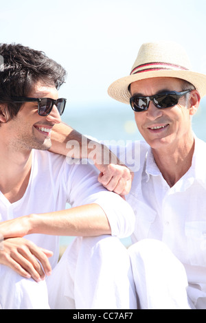 Vater und Sohn gemeinsam unter der Sonne aalen Stockfoto
