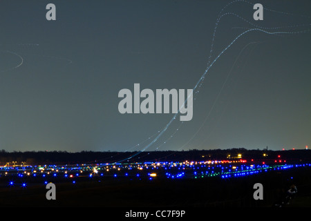 Lichtspuren der Flugzeuge starten in der Nacht Stockfoto