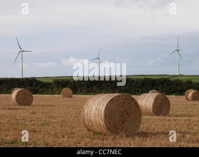 Runde Heuballen und Windkraftanlagen, Cornwall, UK Stockfoto