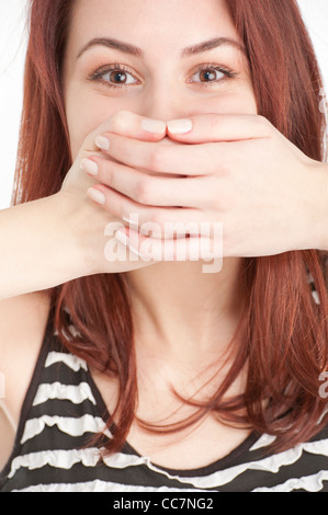 Junge Frau mit Händen den Mund Stockfoto