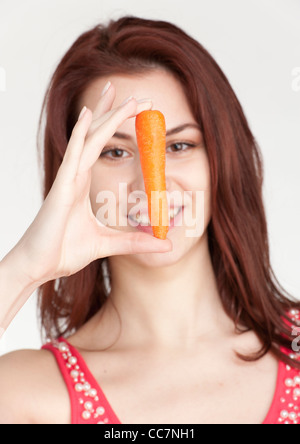 Junge Frau hält eine Bio Karotte Stockfoto