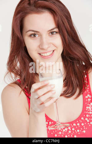 Junge Frau, die Milch aus einem Glas Wein zu trinken Stockfoto