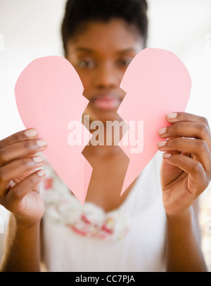 Schwarze Frau mit Papierherz gebrochen Stockfoto