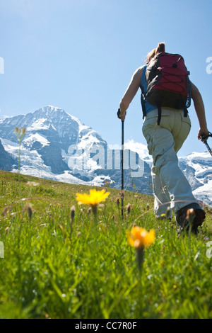 Rückansicht der Frau Wandern mit Stöcken, Berner Oberland, Schweiz Stockfoto
