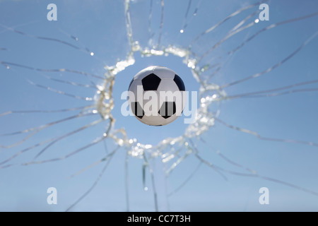 Soccer Ball Zerschlagung durch Fenster Stockfoto
