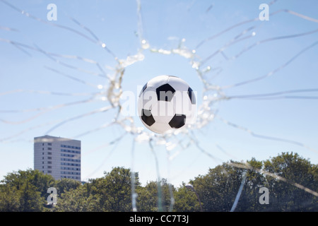 Soccer Ball Zerschlagung durch Fenster Stockfoto