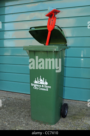 Unerwünschte Rakel oder auf dem Boden Mop weggeworfen in Brighton und Hove City Council Wheelie Haushalt Mülltonne zur Abholung bereit Stockfoto