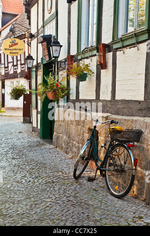 Fahrrad in einer gepflasterten Straße von mittelalterlichen Fachwerkhäusern in der UNESCO-Welterbe-Stadt Quedlinburg, Deutschland. Stockfoto