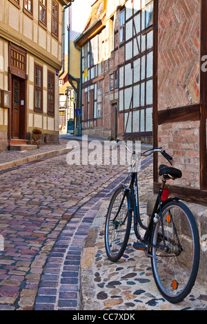 Fahrrad in einer gepflasterten Straße von mittelalterlichen Fachwerkhäusern in der UNESCO-Welterbe-Stadt Quedlinburg, Deutschland. Stockfoto