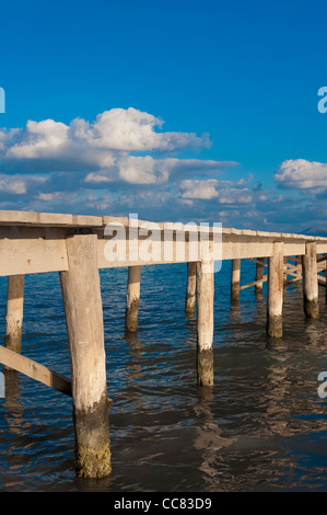 Hölzerne Pier erstreckt sich in einem schönen blauen Meer in Alcudia, Mallorca, Spanien. Stockfoto