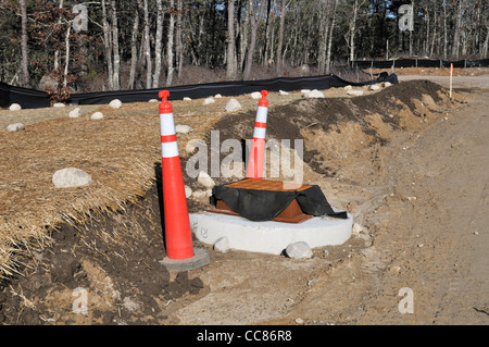 Neue unbefestigte Straße Baustelle mit Sturm abflußabfluß an Stelle Stockfoto